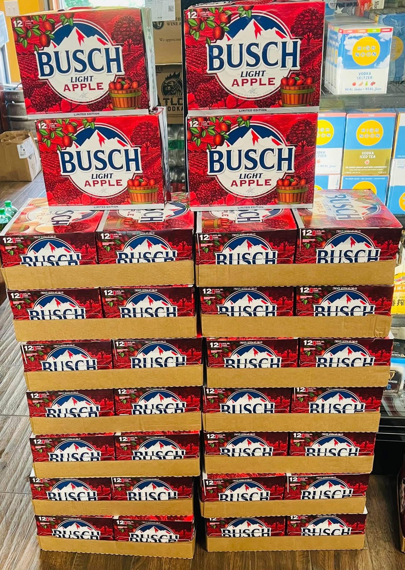 Beer and seltzer selection at Full Proof Liquor, including stacked Busch Light Apple cases and High Noon vodka seltzer packs
